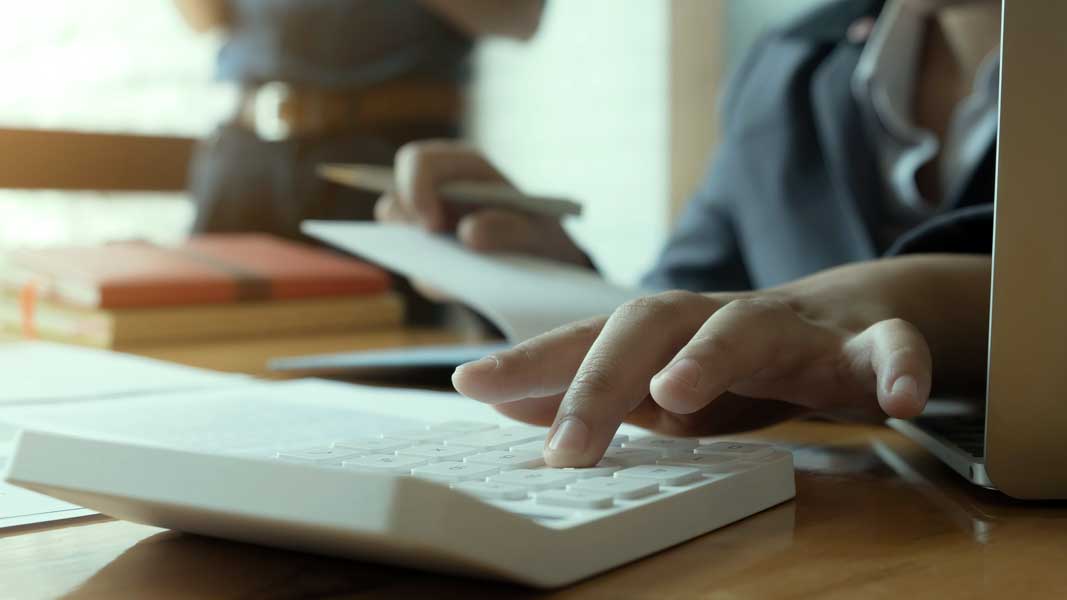 Close up view of bookkeeper or financial inspector hands making Manually calculating DSCR Loan using calculator