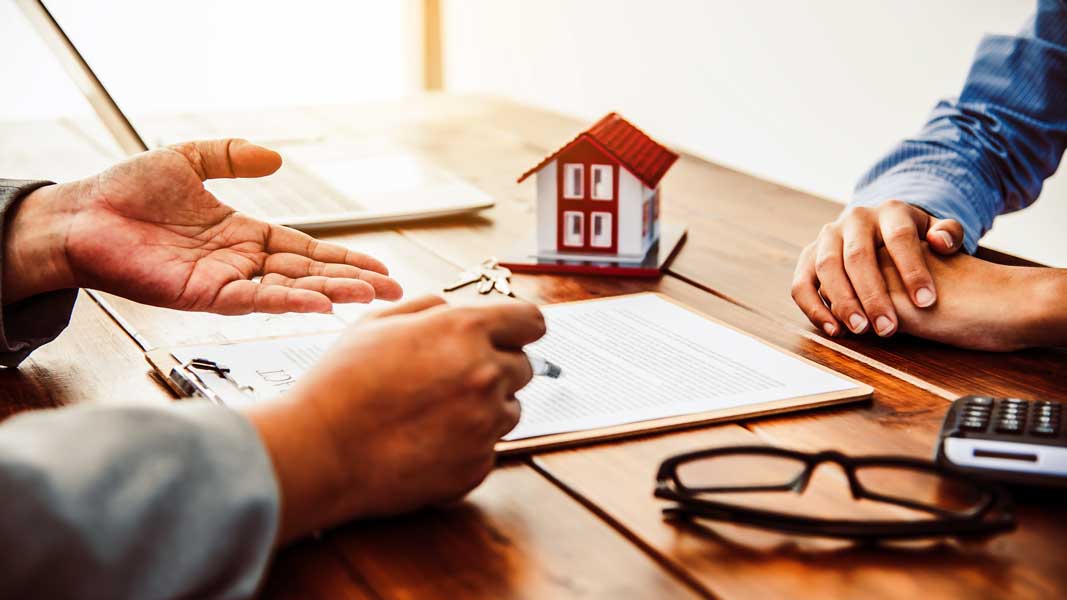 House signers signing signature loan document to home ownership Private lender in Hawaii discussing cash-out refinance with homeowner